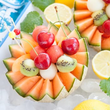 Fresh fruit salad in melon cooled on ice