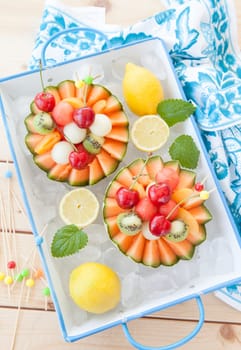 Fresh fruit salad in melon cooled on ice