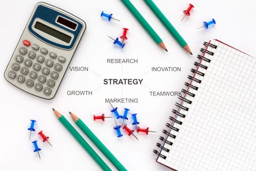 Calculator,notebook,pencils,pushpins and business strategy.