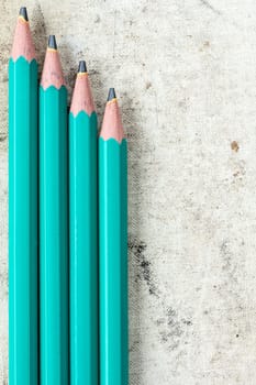 Four pencils on old canvas background with copy-space