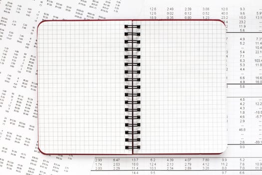 Blank spiral notebook and financial documents. Copy-space.
