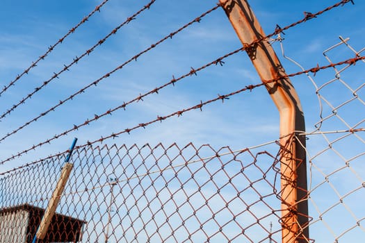 Rusty barbed wire with blue sky