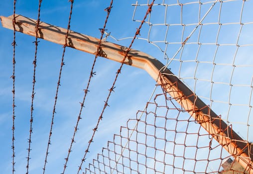Rusty barbed wire with blue sky