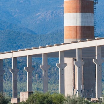 red and white chimney with industrial building