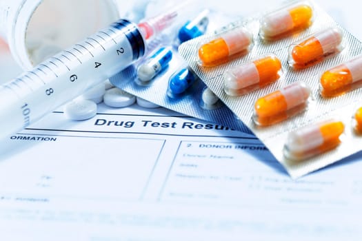 Syringe with glass vials and medications pills drug on white