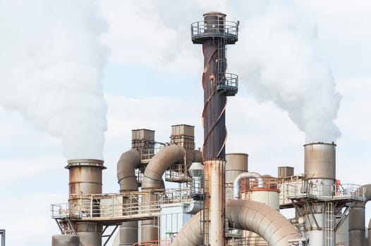 Industrial plant of a furniture factory with smoking smokestack,tube,silos.