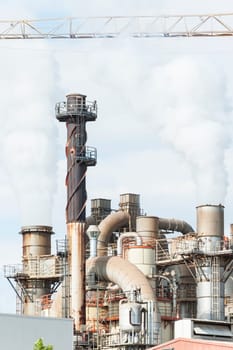 Industrial plant of a furniture factory with smoking smokestack,tube,silos.