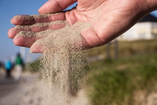 Sand running through hands on beach