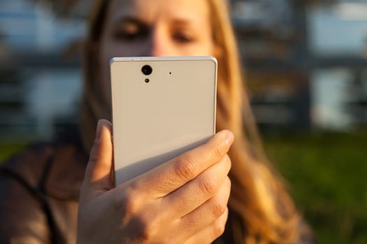 woman with white smartphone in sunlight