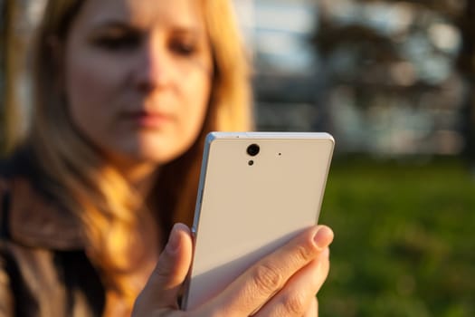 woman with apathetically face and smartphone in nature