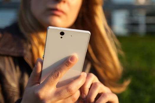 woman looking on smartphone in sunlight