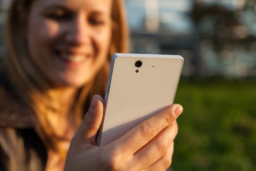 smiling woman and white smarpthone in sunlight