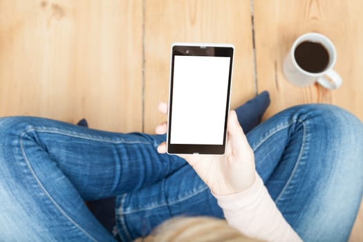 woman looking at smartphone with wooden floor