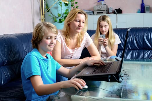 blond mother and her children using computer together