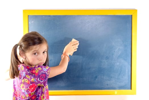 a pretty schoolgirl erases on the blackboard