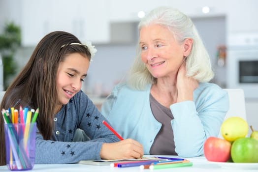 Little girl drawing wuth grandma