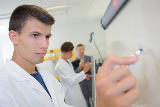 Young man writing on whiteboard
