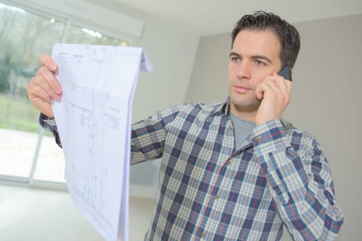 Builder phoning architect to check plans