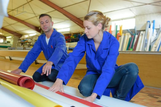 Man and woman looking at rolls of material