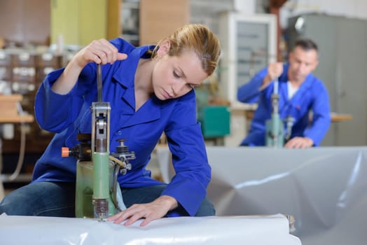 Woman sewing through plastic sheeting