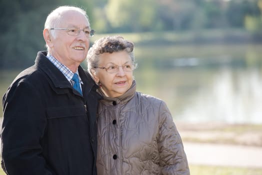 elderly couple beside a lake