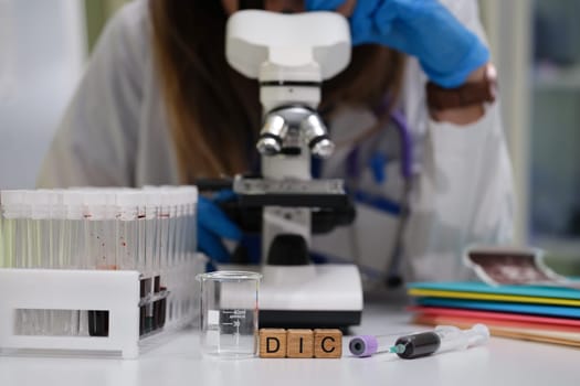 A dedicated scientist meticulously examines various samples under a powerful microscope in a modern laboratory setting