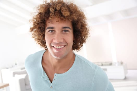Handsome cheerful man standing in new home