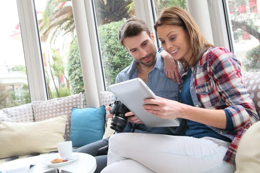 Couple sitting in coffee shop watching photos