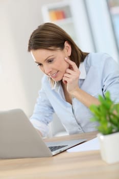 Woman in office working on laptop computer