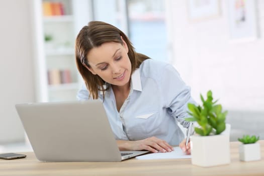 Woman in office working on laptop computer