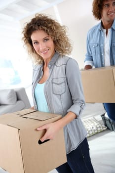 Couple holding boxes as moving in together