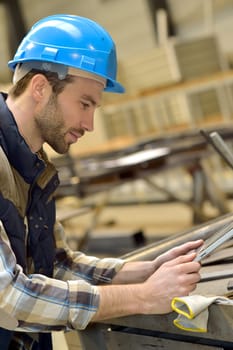 Engineer in metallurgical factory using tablet