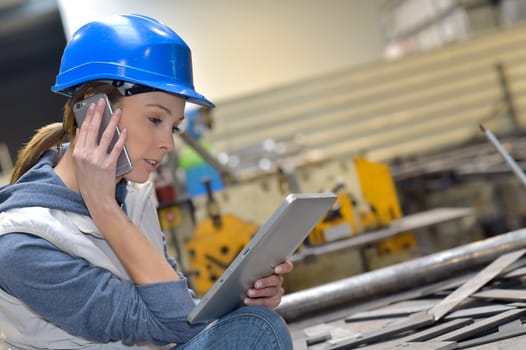 Woman in factory talking on mobile phone
