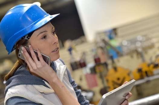 Woman in factory talking on mobile phone