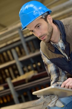 Man in manufacture using digital tablet