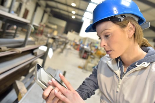 Woman engineer in steel plant checking production