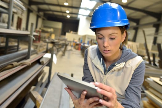 Woman engineer in steel plant checking production