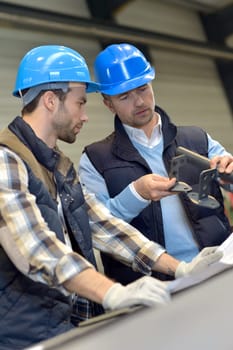 Engineer with mechanical worker checking on production