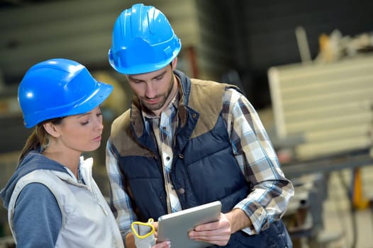 Engineers in steel factory working on digital tablet