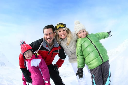 Cheerful family of 4 enjoying winter vacation