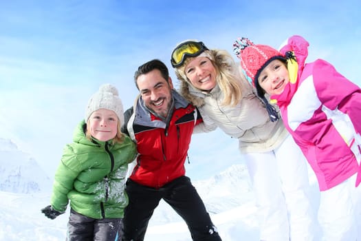 Cheerful family of 4 enjoying winter vacation