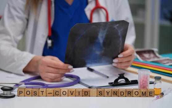A healthcare professional is meticulously analyzing an Xray that is related to postCOVID syndrome observations