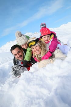 Portrait of happy family laying down in snow