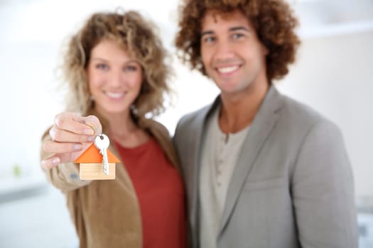 Closeup of hoose key held by cheerful couple