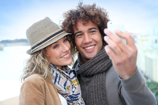 Cheerful couple taking picture with smartphone