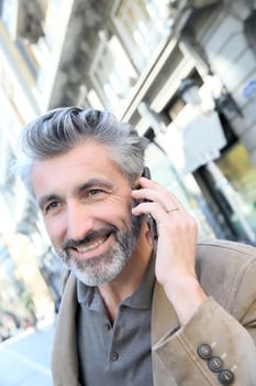 Mature man talking on the phone in the street