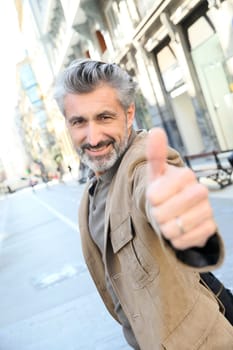 Handsome mature man showing thumb up
