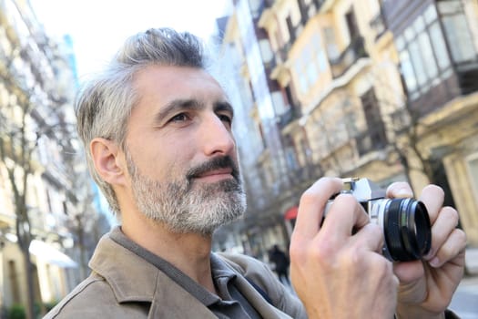 Photographer taking pictures in city street