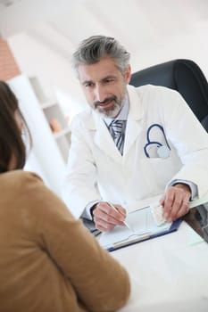 Doctor giving prescription to patient