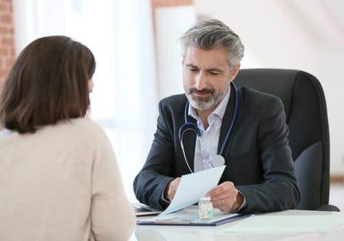 Doctor giving prescription to patient